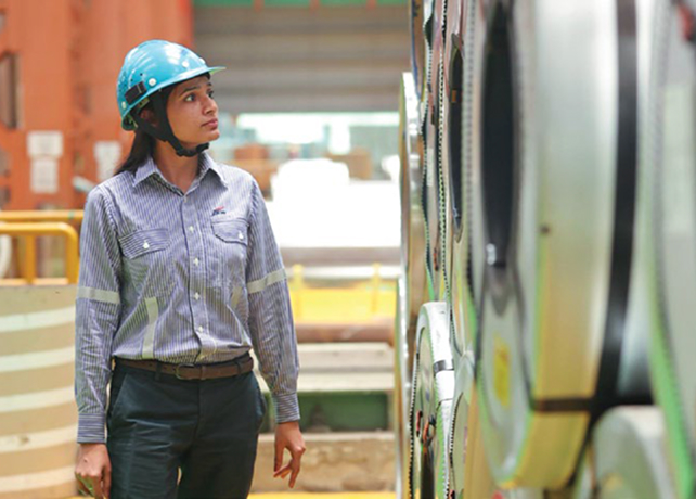 JSW Steel employee inspecting steel coils